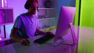 霓虹灯玩家失去轮首页网络空间特写镜头伤心男人。玩电脑游戏
